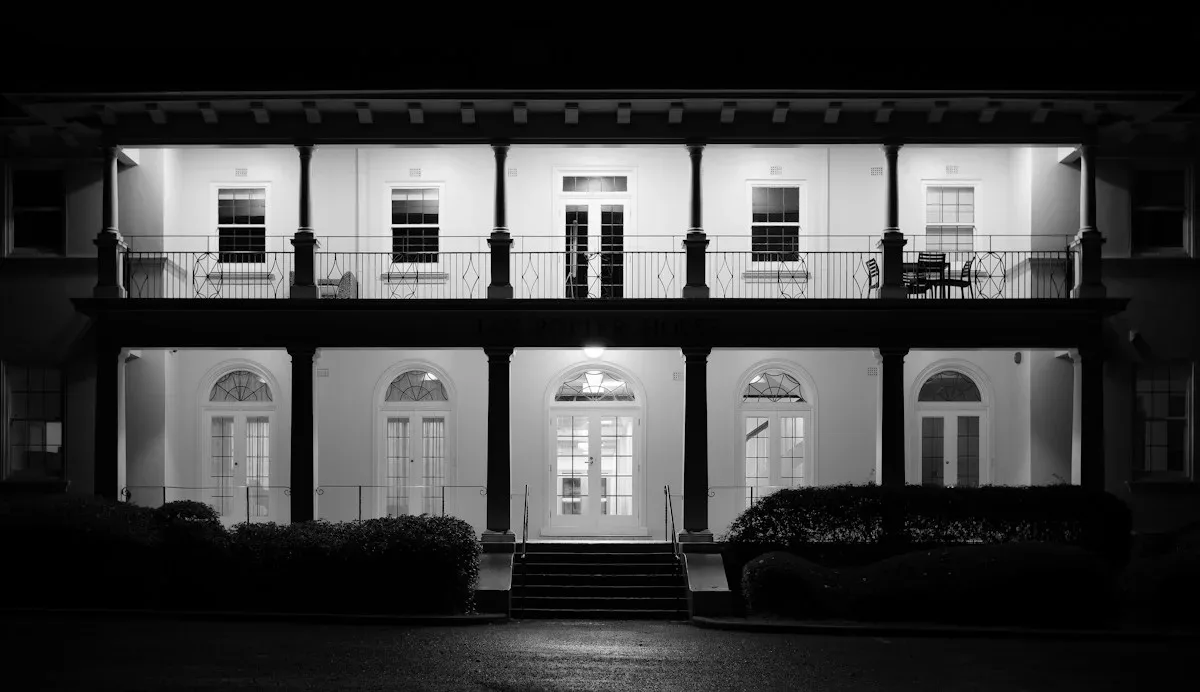 Two-storey building facade and veranda illuminated at night