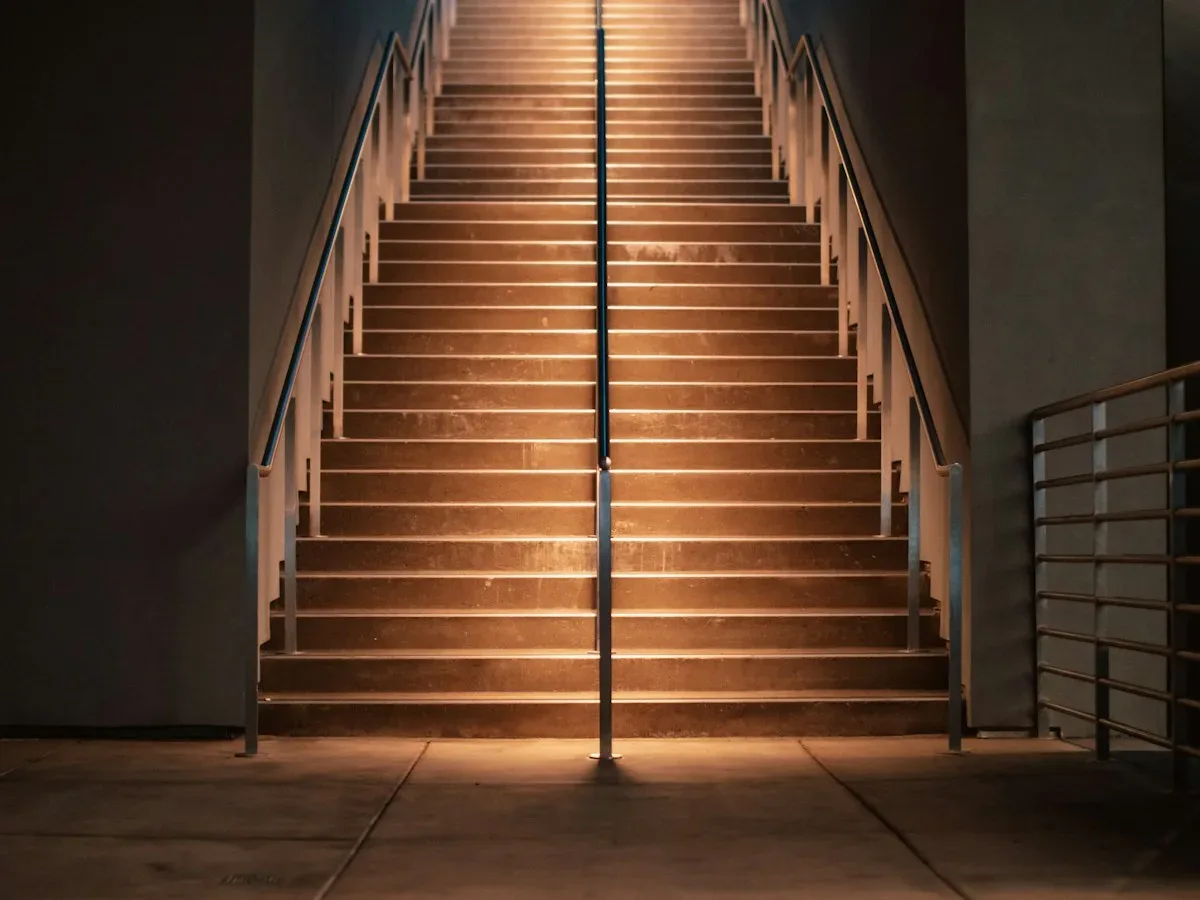 Outdoor staircase with illuminated handrails at night